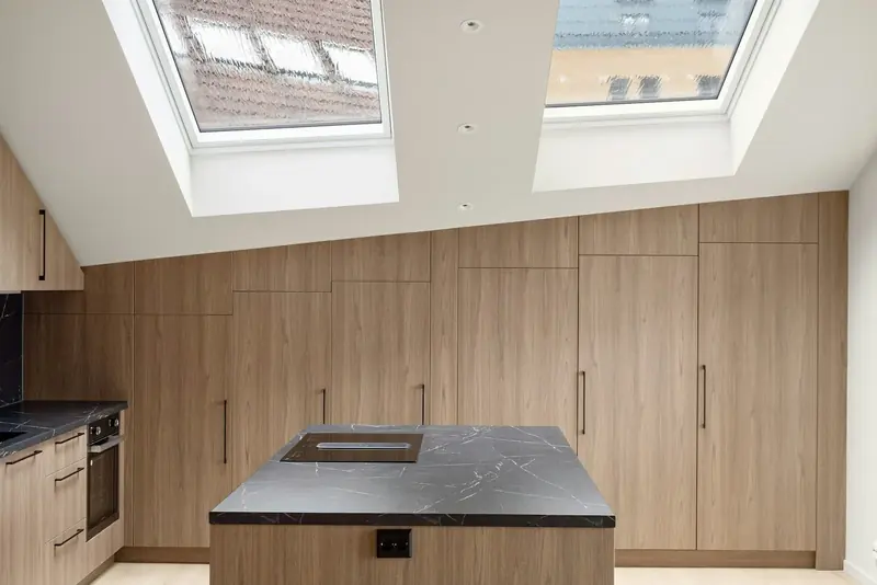 Oak-fronted kitchen with an island, lit by a roof light above