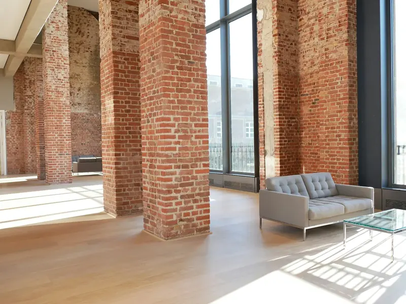 The same brick-piered room with a sofa and low table by the windows
