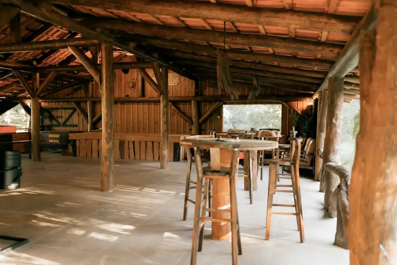 Old timber posts and beams in a long room with high tables and stools