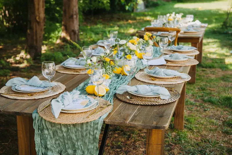 Outdoor table laid with lemons, glassware and woven placemats