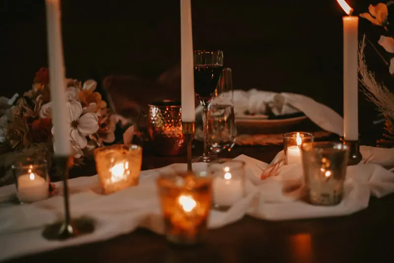 Candlelit table with glass holders and white linen